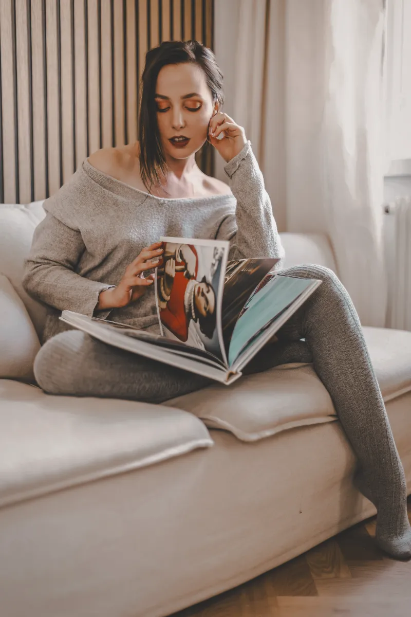 Eine Klientin – in diesem Fall das Modell einer früheren Session – blättert an einem stillen Nachmittag in einem fertigen Photobuch.